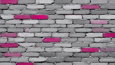 The primary subject of the image is a brick wall with a pink and grey color scheme. The setting is a brick wall, and the visual style is a photo. The dominant colors are pink and grey, creating a unique and visually interesting atmosphere.