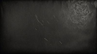 The primary subject of the image is a black background with a white line. The setting is a dark room, and the visual style is a black and white photo. The colors and mood of the image are predominantly dark and moody, with the white line being the only bright element in the scene.