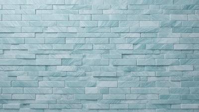 The primary subject of the image is a large, blue marble tile wall. The setting is a bathroom, as indicated by the blue tiles. The visual style is a photo, showcasing the intricate design of the tiles. The dominant colors are blue and white, creating a clean and modern atmosphere.