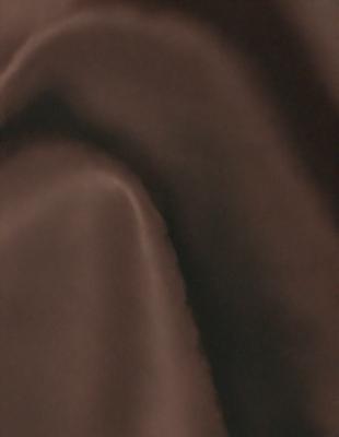 The primary subject of the image is a brown fabric, possibly a blanket or a piece of clothing. The setting is a dark room, and the visual style appears to be a close-up of the fabric. The colors and mood of the image are predominantly dark and moody, with the brown fabric being the main focus.