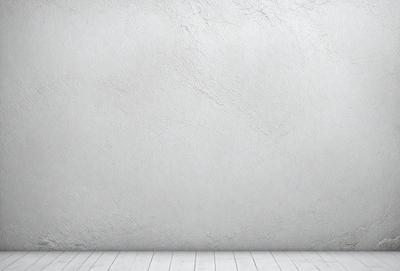 The primary subject of the image is a white wall with a grey texture. The setting is a room with a white floor. The visual style is a photo, and the colors and mood are predominantly white and neutral.