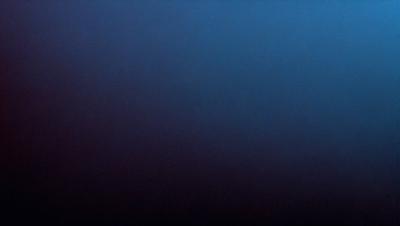 The primary subject of the image is a dark blue ocean with a few ripples. The setting is a vast expanse of water, and the visual style is a photo. The colors and mood of the image are predominantly dark and moody, with the blue ocean being the main focus.