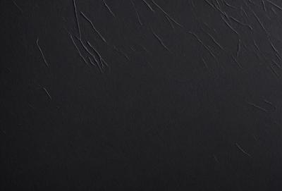 The primary subject of the image is a black background with a texture that resembles a painting or a drawing. The setting is a dark room, and the visual style appears to be a combination of a photo and a painting. The colors are predominantly black, and the overall atmosphere is moody and dramatic.