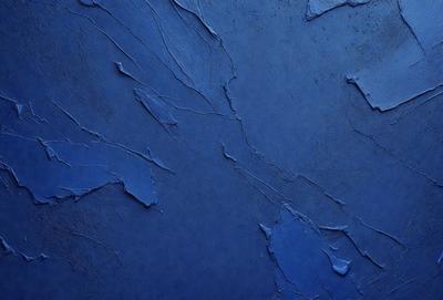 The primary subject of the image is a blue wall with a textured surface. The setting is a room with a blue wall, and the visual style is a close-up of the wall. The dominant colors are blue and grey, creating a calm and soothing atmosphere.