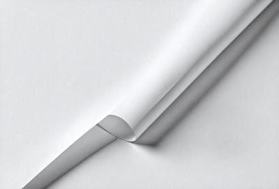 The primary subject of the image is a white sheet of paper. The setting is a white background, which creates a clean and minimalistic visual style. The paper appears to be folded or creased, giving it a unique texture and mood. The overall atmosphere is calm and uncluttered.