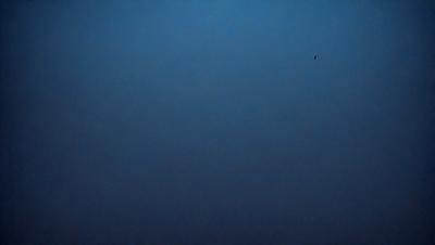 The primary subject of the image is a blue sky with no clouds. The setting is a vast, open space with no visible landmarks or objects. The visual style is a simple, clean, and minimalistic representation of the sky. The colors and mood are predominantly blue, creating a calm and serene atmosphere.