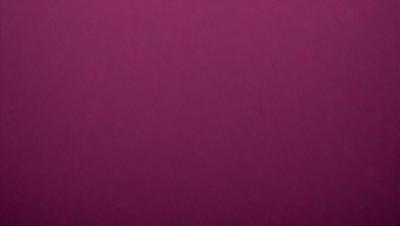 The primary subject of the image is a large, purple wall. The setting is a room with a pink background. The visual style is a close-up of the wall, which gives a sense of depth and texture. The dominant colors are purple and pink, creating a warm and inviting atmosphere.