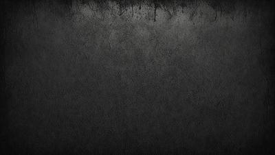 The primary subject of the image is a black and white photo of a wall. The setting is a dark room, and the visual style is a close-up of the wall. The colors and mood of the image are predominantly dark and moody, with the black and white color scheme adding to the atmosphere.