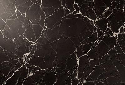 The primary subject of the image is a black marble countertop with a pattern of white veins. The setting is a kitchen, and the visual style is a close-up of the marble countertop. The dominant colors are black and white, creating a sleek and elegant atmosphere.