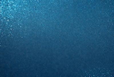 The primary subject of the image is a blue background with a shiny, reflective surface. The setting appears to be a dark room, and the visual style is a close-up of the blue background. The colors and mood of the image are predominantly dark and moody, with the blue background being the main focus.