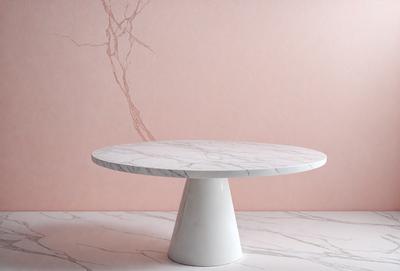 The primary subject of the image is a white round table with a marble top. The table is placed on a marble floor, which serves as the setting for the scene. The visual style of the image is a photo, capturing the details of the table and its surroundings. The colors and mood of the image are predominantly white, giving it a clean and elegant appearance.