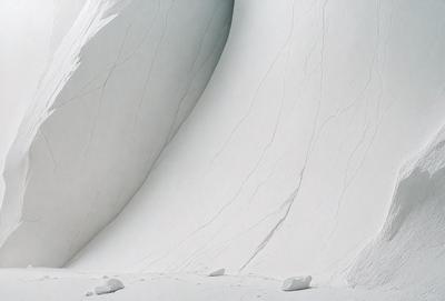 The image features a large, curved, white wall with a few small rocks scattered around it. The wall appears to be made of marble, giving it a smooth and polished appearance. The rocks are positioned at various distances from the wall, with some closer to the foreground and others further away. The overall atmosphere of the scene is clean and minimalistic, with the focus on the curved wall and the small rocks.