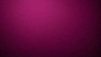 The primary subject of the image is a large, purple wall. The setting is a room with a pink background, which creates a warm and inviting atmosphere. The visual style is a close-up of the wall, showcasing its vibrant color. The dominant colors are purple and pink, giving the scene a cozy and comfortable feel.