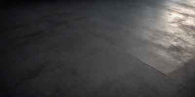 The primary subject of the image is a large, dark grey floor. The setting is a room with a dark grey floor, which appears to be a concrete surface. The visual style of the image is a photo, capturing the details of the floor. The colors and mood of the image are dark and moody, with the grey floor being the dominant color.
