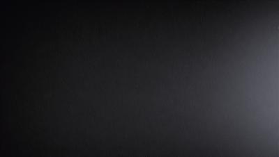 The primary subject of the image is a black background with a few stars visible. The setting is a dark, starry sky, and the visual style is a black and white photo. The colors and mood of the image are predominantly dark and moody, with the stars providing a touch of brightness.