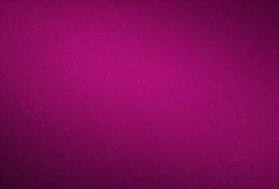 The primary subject of the image is a large, purple wall. The setting is a room with a pink background, which creates a contrasting and vibrant atmosphere. The visual style is a close-up of the wall, showcasing its color and texture. The dominant colors are purple and pink, giving the image a warm and inviting mood.