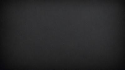 The image is a black and white photo of a dark background.