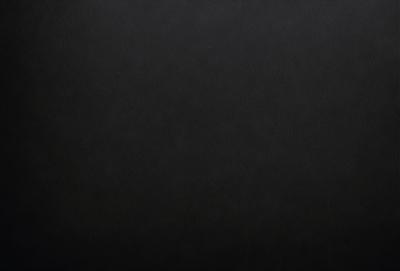 The primary subject of the image is a black background. The setting is a dark room, and the visual style is a black and white photo. The colors and mood of the image are dark and moody, creating a sense of mystery or drama.