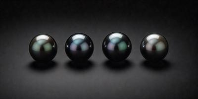The image features a group of five black pearl-like balls, each with a slightly different shape and size. They are arranged in a row, with one ball slightly larger than the others. The setting is a dark background, which contrasts with the black pearls, making them stand out. The visual style appears to be a close-up of the pearls, showcasing their unique characteristics. The overall atmosphere is elegant and sophisticated, as the pearls are the main focus of the image.