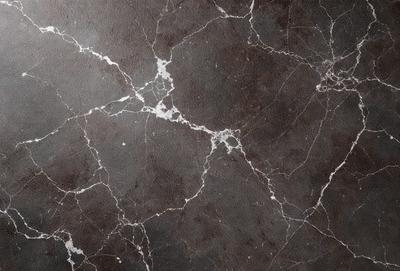 The image features a marble wall with a pattern of white and brown spots. The wall appears to be textured and has a unique design. The primary subject of the image is the marble wall, which serves as the main focus of the scene. The setting is indoors, likely in a room with a modern or contemporary design. The visual style of the image is a close-up of the marble wall, showcasing its intricate pattern and texture. The colors and mood of the image are predominantly neutral, with the white and brown spots on the marble wall creating a sense of sophistication and elegance.