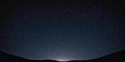 The primary subject of the image is the night sky filled with stars. The setting is a dark, starry night with a mountainous landscape in the background. The visual style is a black and white drawing, giving the image a classic and timeless feel. The colors and mood are predominantly dark and moody, with the stars and the mountainous landscape creating a sense of depth and mystery.