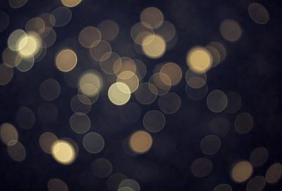 The primary subject of the image is a brightly lit scene with a large number of small, round lights. The lights are scattered throughout the scene, creating a visually striking and luminous atmosphere. The setting appears to be a dark background, which further emphasizes the brightness of the lights. The visual style of the image is a combination of a photo and digital art, as it captures the essence of a brightly lit environment with a unique and artistic touch. The colors and mood of the image are predominantly warm and inviting, with the bright lights creating a sense of warmth and energy.