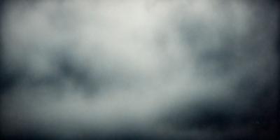 The primary subject of the image is a cloudy sky. The setting is a dark, cloudy day with a gloomy atmosphere. The visual style is a photo, capturing the natural beauty of the cloudy sky. The colors and mood are predominantly dark and moody, with the clouds creating a dramatic backdrop.