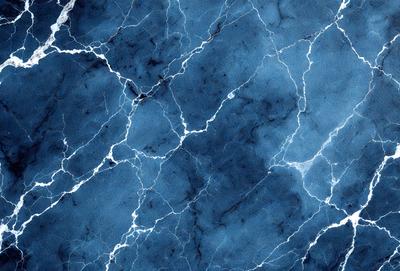 The primary subject of the image is a blue marble wall with a pattern of white and blue veins. The setting is a room with a blue marble wall, and the visual style is a close-up of the marble wall. The colors and mood of the image are predominantly blue, with the white and blue veins adding a touch of contrast and interest to the overall atmosphere.