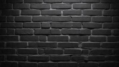 The primary subject of the image is a brick wall. The setting is a dark room, and the visual style is a black and white photo. The dominant colors are black and white, creating a moody atmosphere.