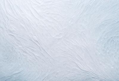 The image features a white, textured surface with a patterned design. The primary subject is the white surface, which appears to be a wall or a piece of artwork. The setting is indoors, with the white surface being the main focus of the image. The visual style is a combination of photo and digital art, creating a unique and intriguing appearance. The colors and mood of the image are predominantly white, giving it a clean and minimalist feel.