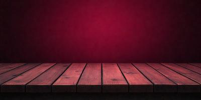 The primary subject of the image is a wooden bench with a red surface. The setting is a red wall, which serves as the background. The visual style is a photo, capturing the bench and the red wall in a realistic manner. The colors and mood of the image are predominantly red, creating a warm and inviting atmosphere.