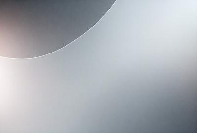The primary subject of the image is a large, round, white object, possibly a wall or a piece of art. The setting is a white background, which creates a clean and minimalist appearance. The visual style is a combination of photo and digital art, as the object appears to be a photograph with a digital artistic touch. The colors and mood of the image are predominantly white, giving it a calm and serene atmosphere.