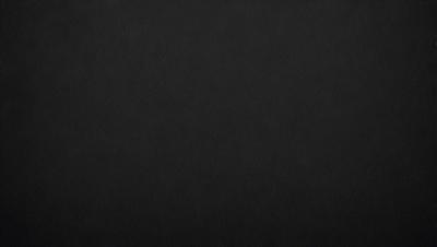 The primary subject of the image is a black background. The setting is a dark room, and the visual style is a black and white photo. The colors and mood of the image are predominantly dark and moody.