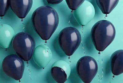 The primary subject of the image is a large group of blue and green balloons. The balloons are arranged in a visually appealing manner, creating a sense of depth and dimension. The setting is a blue and green background, which complements the colors of the balloons. The visual style of the image is a close-up of the balloons, showcasing their vibrant colors and unique shapes. The overall atmosphere of the image is lively and cheerful, as the balloons are often associated with celebrations and joyful events.