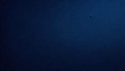 The primary subject of the image is a dark blue sky with no clouds. The setting is a vast, open space with no visible landmarks or objects. The visual style is a simple, clean, and minimalistic representation of the sky. The colors and mood convey a sense of calmness and tranquility.