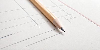 The primary subject of the image is a wooden pencil, which is placed on a piece of paper. The setting is a white surface, likely a piece of paper or a table. The visual style is a close-up of the pencil on the paper, showcasing the details of the pencil and the paper. The colors and mood of the image are predominantly white, giving it a clean and simple appearance.