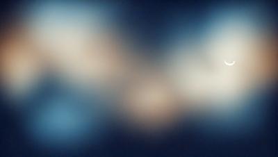 The primary subject of the image is a blue background with a white, glowing, and somewhat blurry shape. The setting appears to be a dark, starry night, with the shape possibly representing a celestial object or a cloud. The visual style of the image is a combination of a photo and a digital art, creating a unique and captivating atmosphere. The colors and mood of the image are predominantly dark and mysterious, with the white shape adding a touch of brightness and contrast to the overall scene.