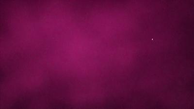The primary subject of the image is a purple background. The setting is a close-up of the purple background, which appears to be a wall or a piece of fabric. The visual style is a close-up of the purple background, which gives a sense of depth and texture to the image. The colors and mood of the image are predominantly purple, creating a calm and soothing atmosphere.