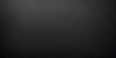 The primary subject of the image is a black background with a grayish tint. The setting is a dark room, and the visual style is a black and white photo. The colors and mood of the image are dark and moody, creating a sense of mystery or drama.