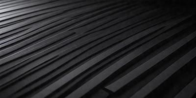 The primary subject of the image is a black and white patterned surface, which appears to be a textured wall or a black and white tile. The setting is a dark room, and the visual style is a close-up of the patterned surface. The colors and mood of the image are predominantly dark and moody, with the black and white pattern creating a sense of depth and contrast.