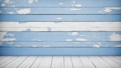 The primary subject of the image is a blue wall with white clouds painted on it. The setting is a room with a wooden floor. The visual style is a painting, and the colors and mood are predominantly blue and white, creating a calm and serene atmosphere.