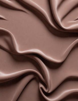 The primary subject of the image is a close-up of a brown fabric, possibly a piece of chocolate-colored velvet. The setting is a wall, and the visual style appears to be a pattern or texture. The colors and mood of the image are predominantly brown, giving it a warm and cozy atmosphere.