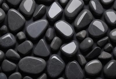 The primary subject of the image is a collection of black rocks, which are arranged in a visually appealing manner. The setting is a black background, which provides a striking contrast to the rocks. The visual style of the image is a close-up of the rocks, showcasing their unique shapes and textures. The dominant colors in the image are black and grey, creating a moody and dramatic atmosphere.