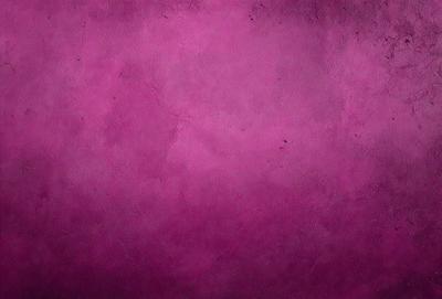 The primary subject of the image is a purple wall with a textured surface. The setting is a room with a purple wall, and the visual style is a close-up of the wall. The dominant colors are purple and pink, creating a warm and inviting atmosphere.