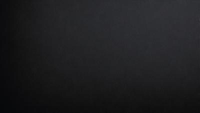 The primary subject of the image is a black background. The setting is a dark room, and the visual style is a black and white photo. The colors and mood of the image are predominantly dark and moody, creating a dramatic atmosphere.