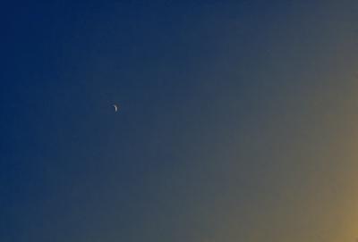 Primary subject: A moon in the sky.

Setting/background: A clear blue sky.

Visual style: A photo.

Colors and mood: The sky is blue, and the moon is white, creating a serene and peaceful atmosphere.