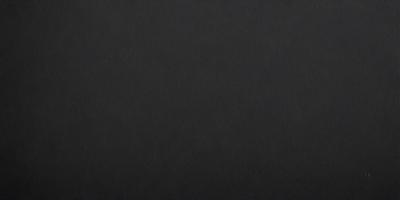 The primary subject of the image is a black background. The setting is a dark room, and the visual style is a black and white photo. The colors and mood of the image are dark and moody, creating a sense of mystery or drama.