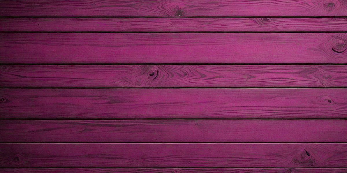 The primary subject of the image is a wooden wall with a purple hue. The setting is a room with a wooden surface, and the visual style appears to be a photo. The dominant colors are purple and brown, creating a warm and inviting atmosphere.
