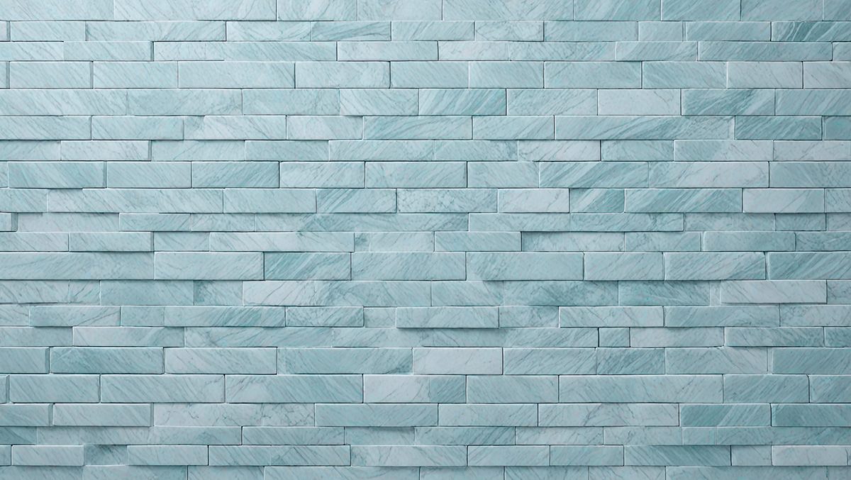 The primary subject of the image is a large, blue marble tile wall. The setting is a bathroom, as indicated by the blue tiles. The visual style is a photo, showcasing the intricate design of the tiles. The dominant colors are blue and white, creating a clean and modern atmosphere.