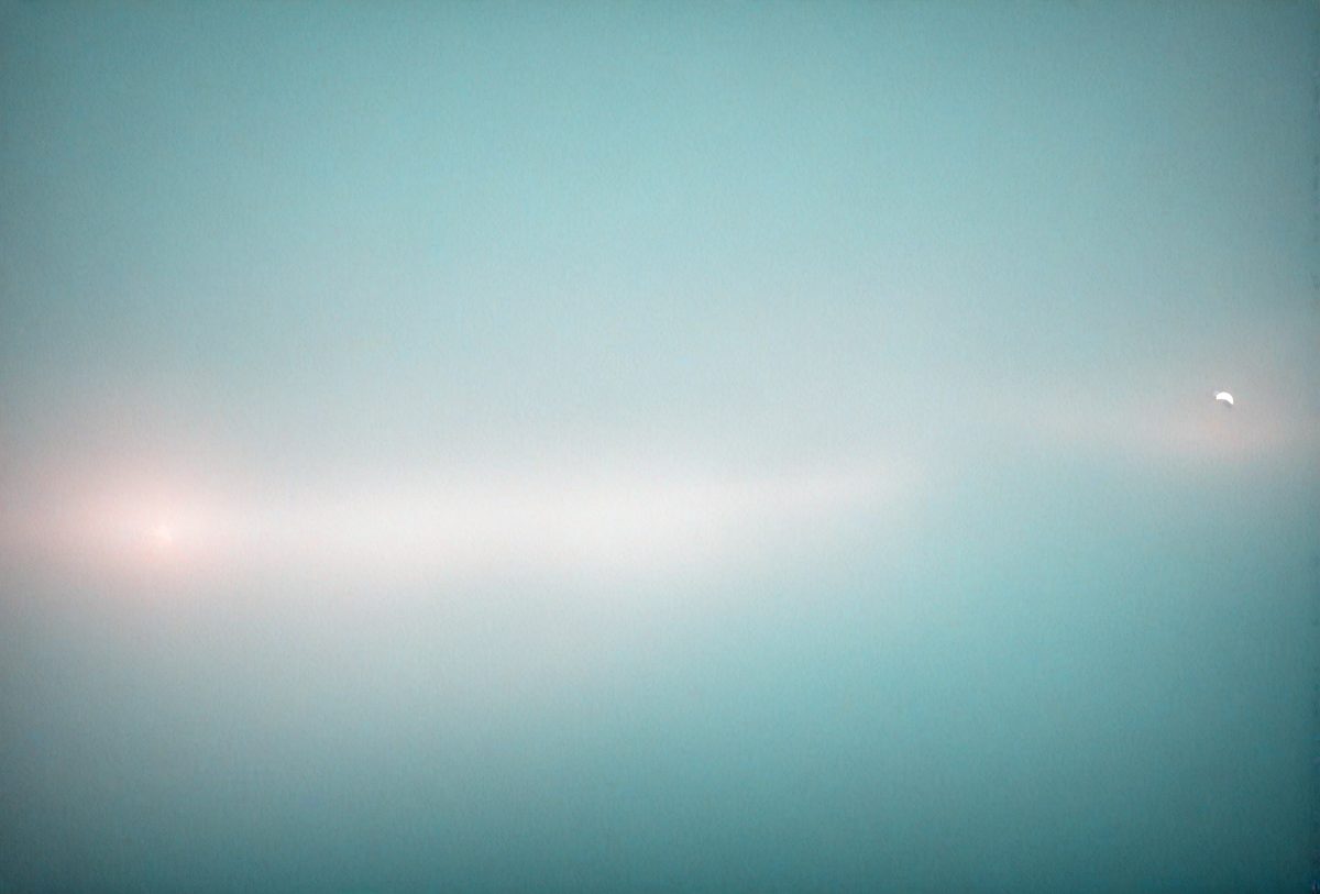 The primary subject of the image is a large, empty, and dark blue sky. The setting is a vast, open space with no visible landmarks or objects. The visual style is a natural, untouched landscape, and the colors and mood are serene and tranquil.